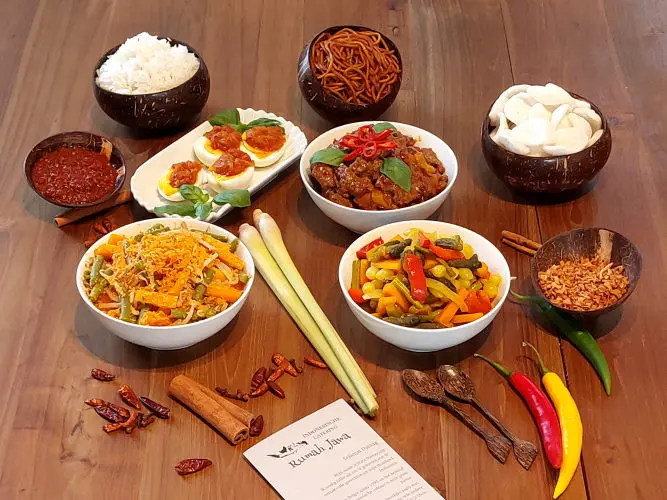 Rijsttafel Sederhana (Daging lada hitam – rundvlees zwarte peper, Acar kuning – ingelegde gele groenten, Orak arik – gebakken kool met ei, Besengek tempe tahu – tofu met currysaus, Bami Goreng - gebakken noedels, Verpakking in Rumah Jawa-stijl)